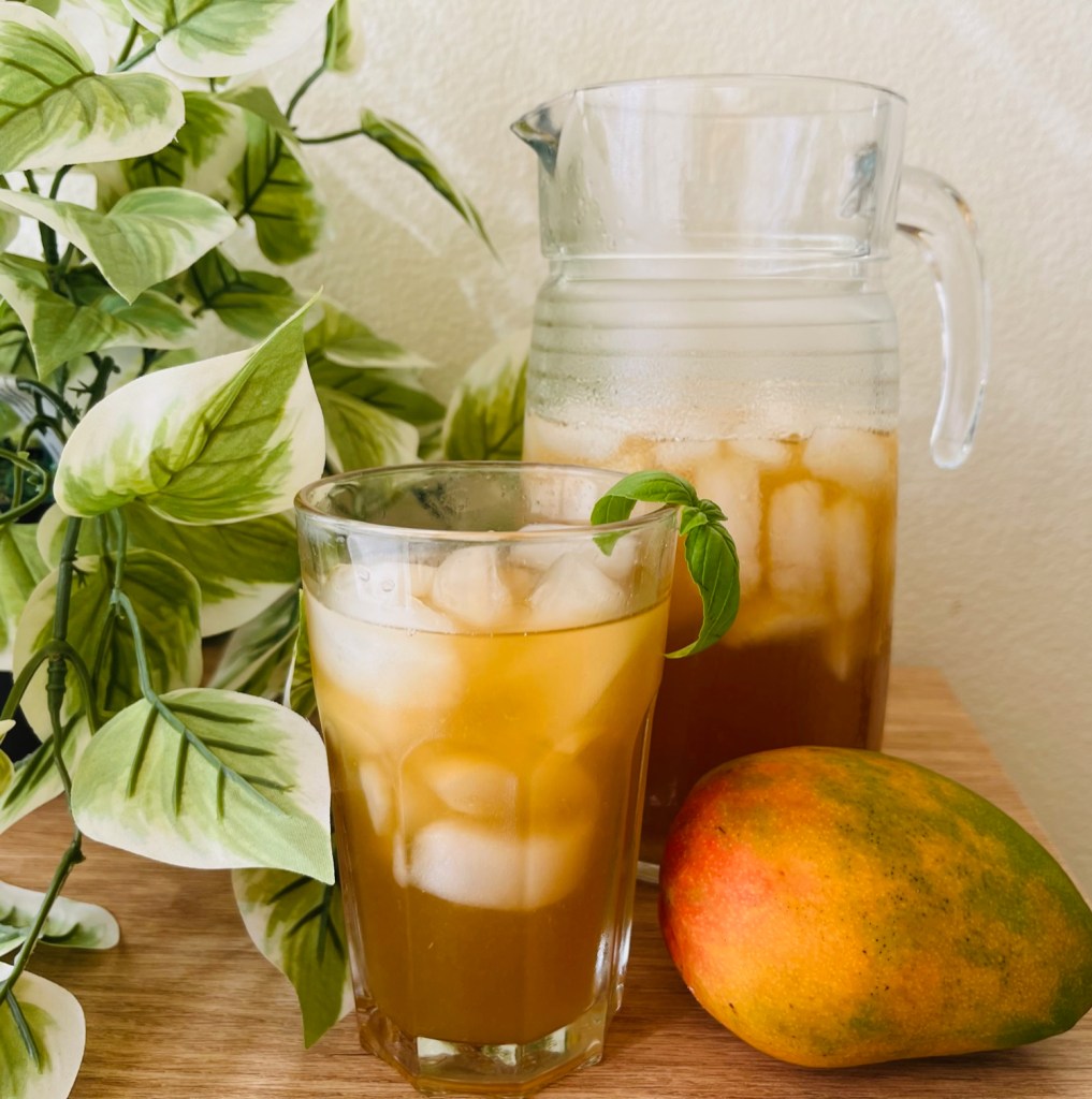 Hibiscus and mango iced tea with some basil leaves