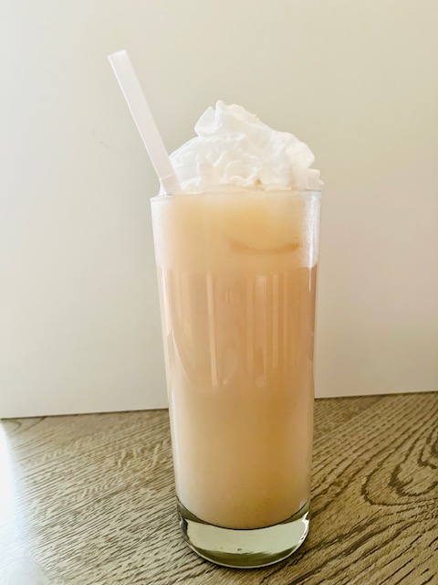 Iced caramel latte served with whipped cream