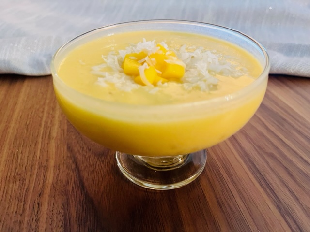 Mango coconut sago topped with coconut flakes and chopped mango.
